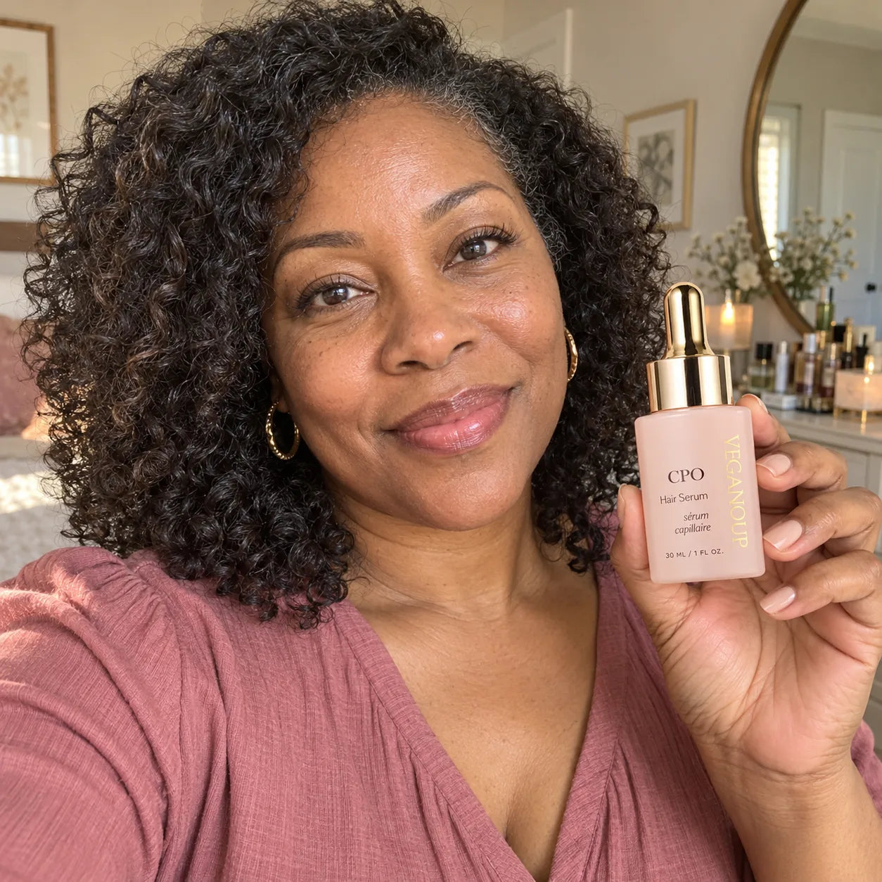 AI model holding CPO Hair Serum near a bedroom vanity