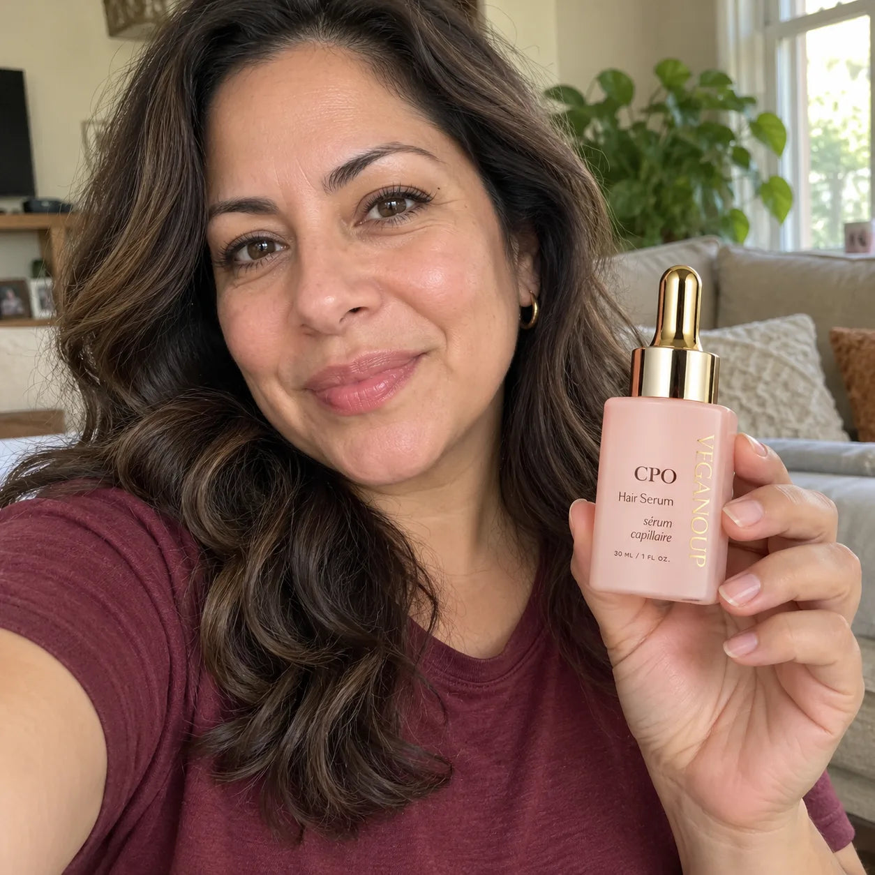 AI model holding CPO Hair Serum in a living room