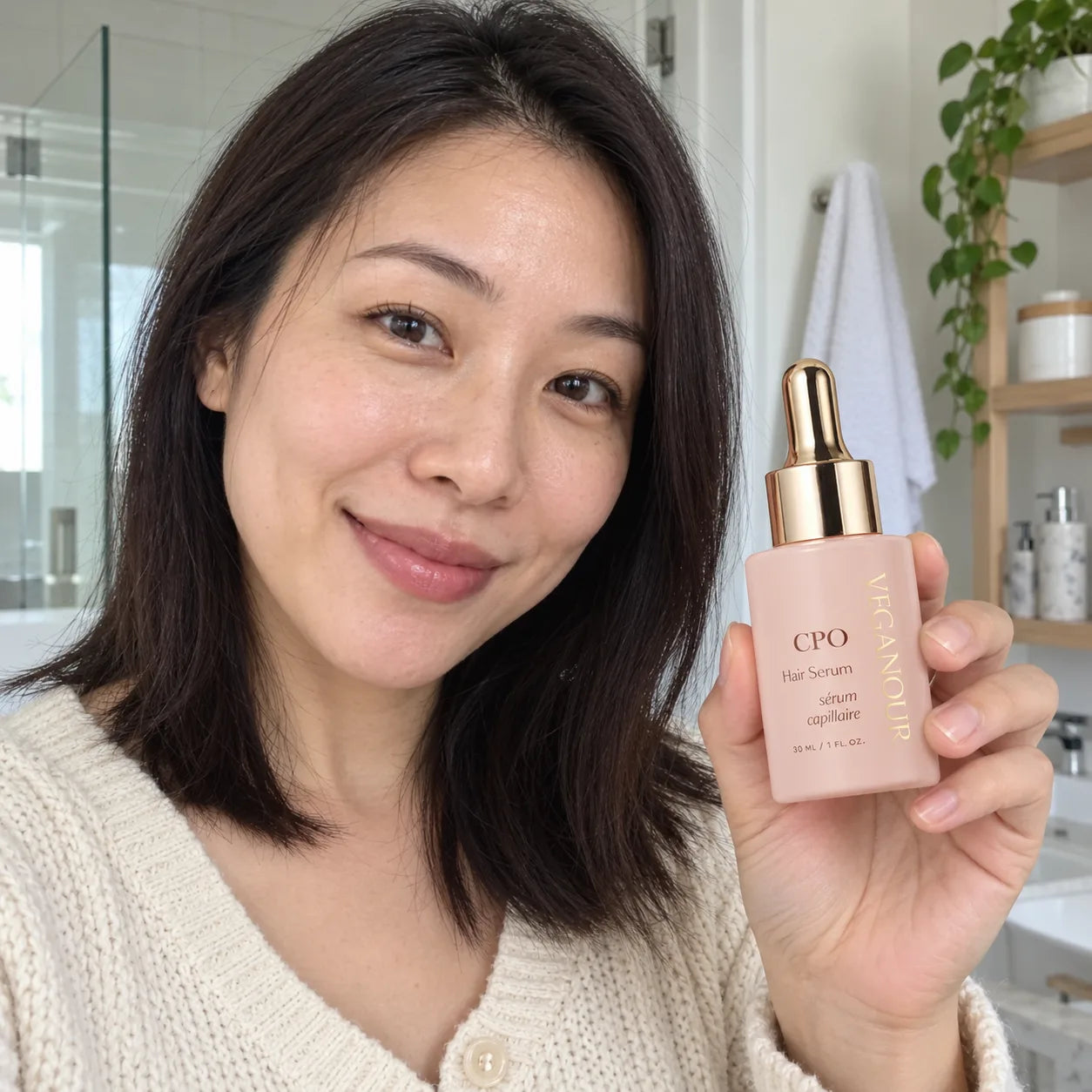 AI model holding CPO Hair Serum in a bathroom setting